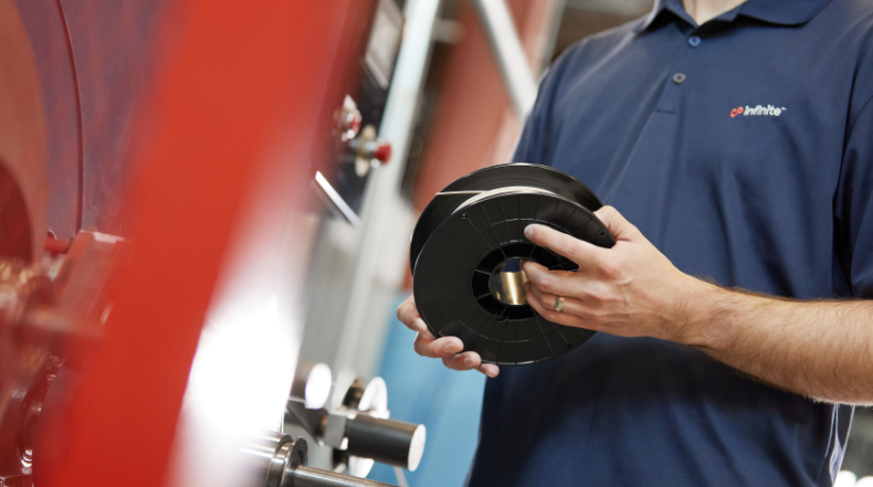 Intinite employee holding a caverna filament spool